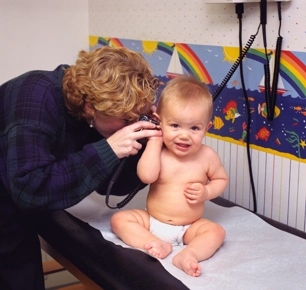 A doctor examining a baby's ear.