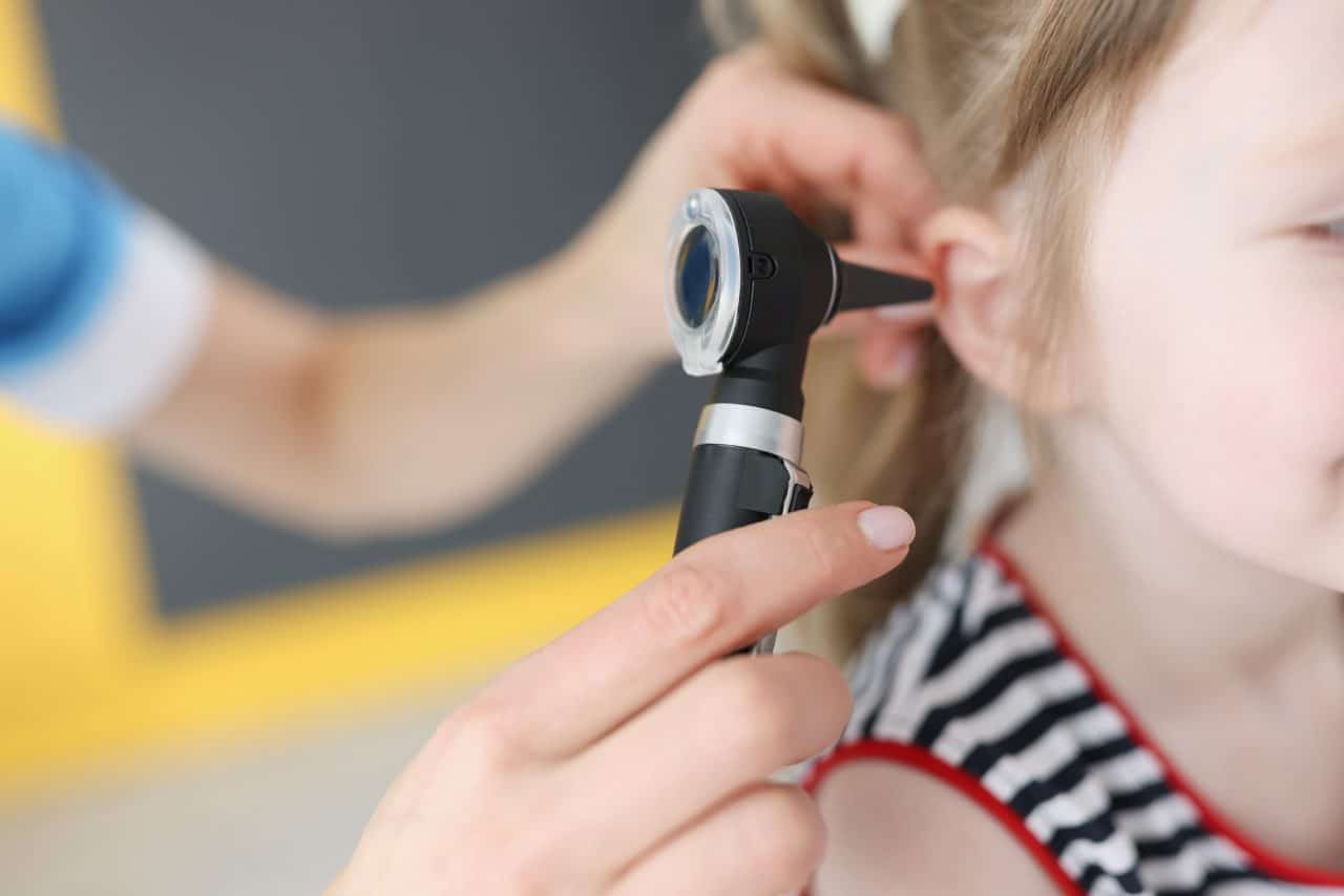 Little girl getting her ear examined by a doctor.
