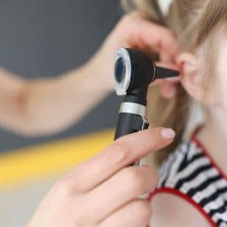 Little girl getting her ear examined by a doctor.