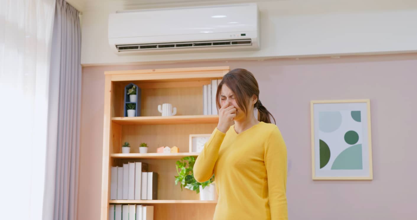 Woman sneezing in her office