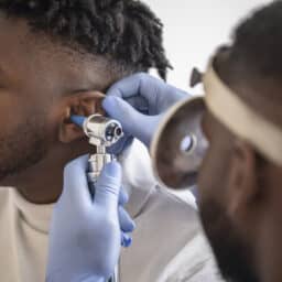 Doctor checking a man's eardrum