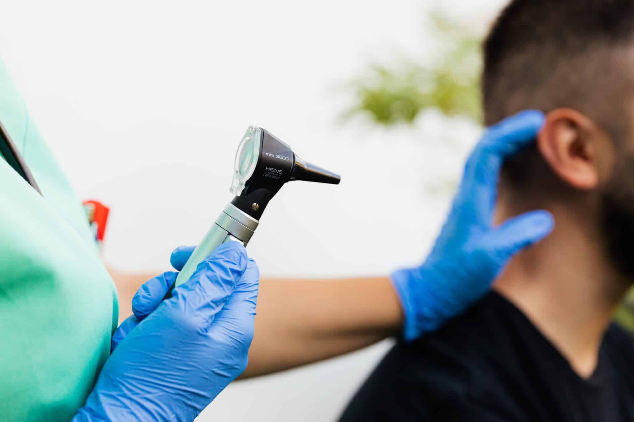 Doctor performing an ear exam on a patient.