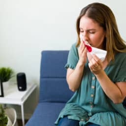 Woman leaning forward with a nosebleed