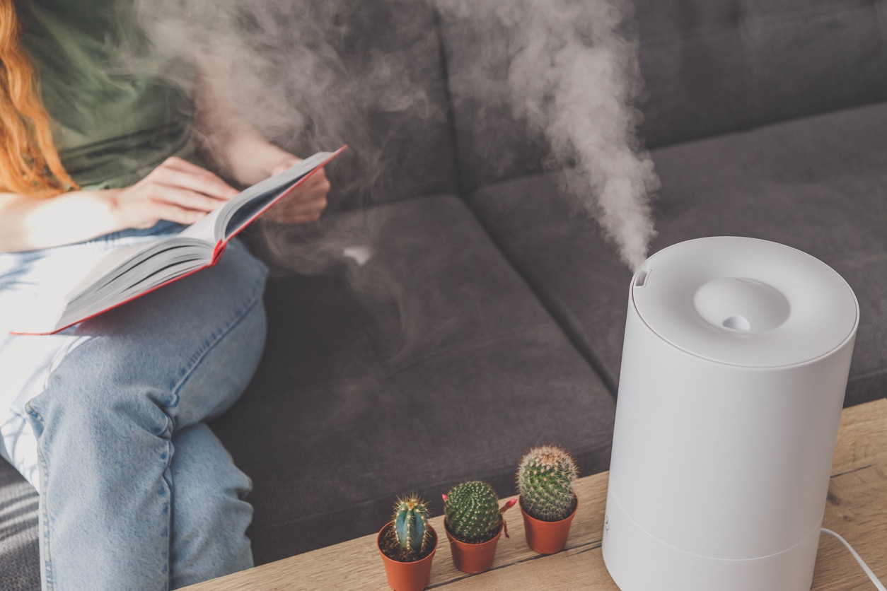 Woman reading next to a humidifier 
