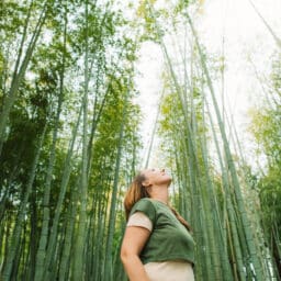 Woman standing in a bamboo forest enjoying earth day