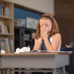 Young girl blows her nose