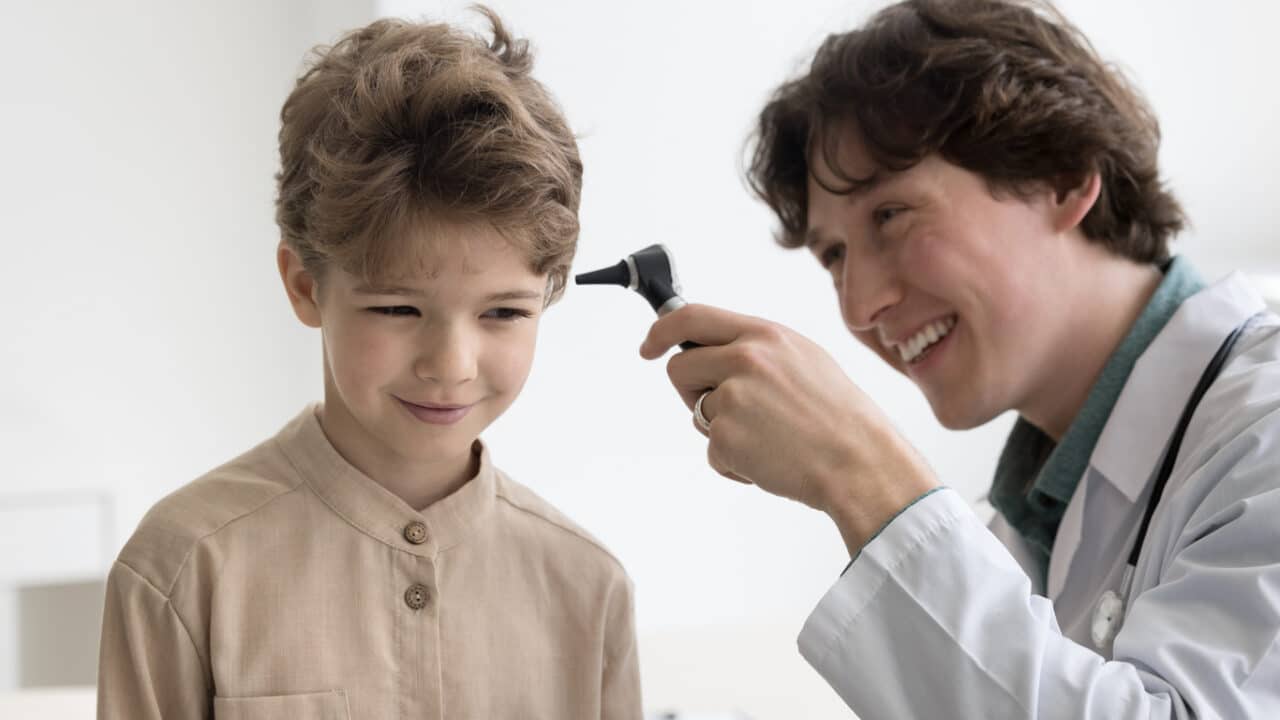 Young boy smiling in an ear exam.