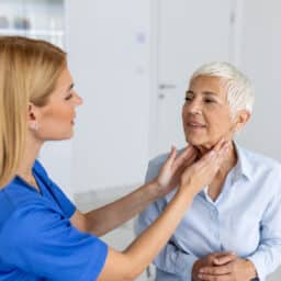 Provider examining a senior woman's throat