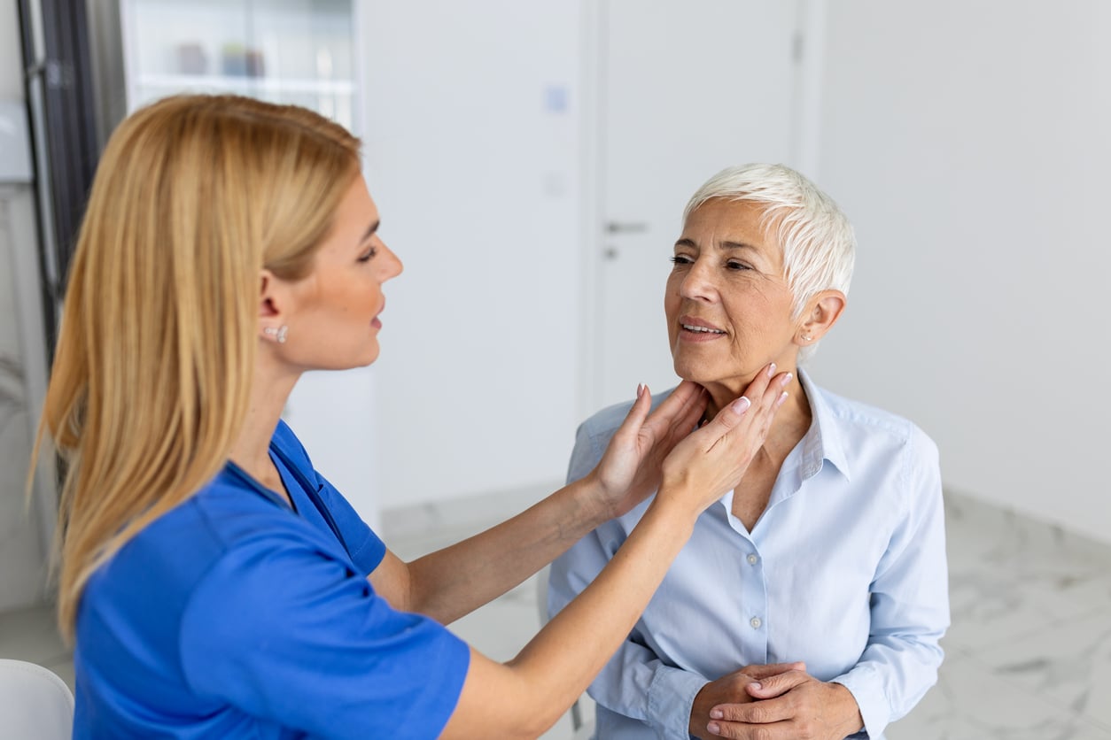 Provider examining a senior woman's throat.