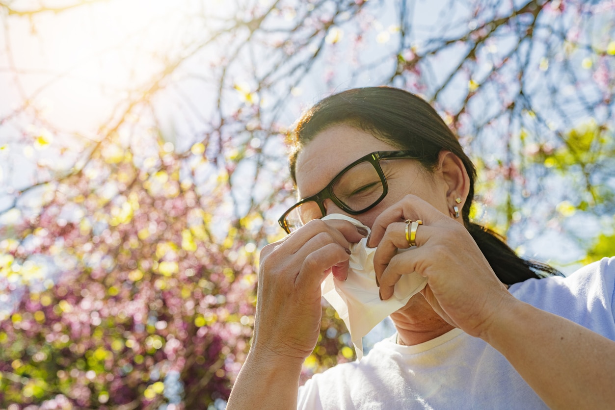 Woman blows nose in a park