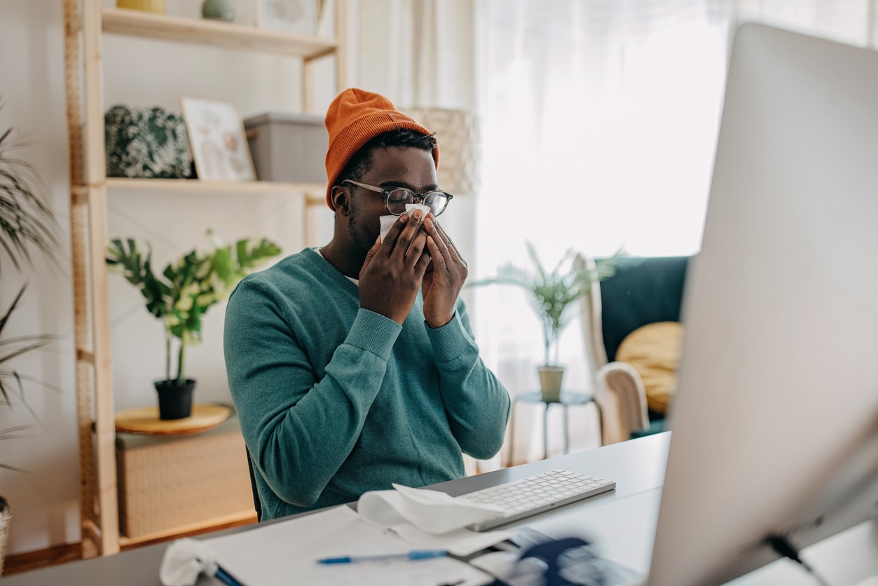 Man with sinusitis blowing his nose.