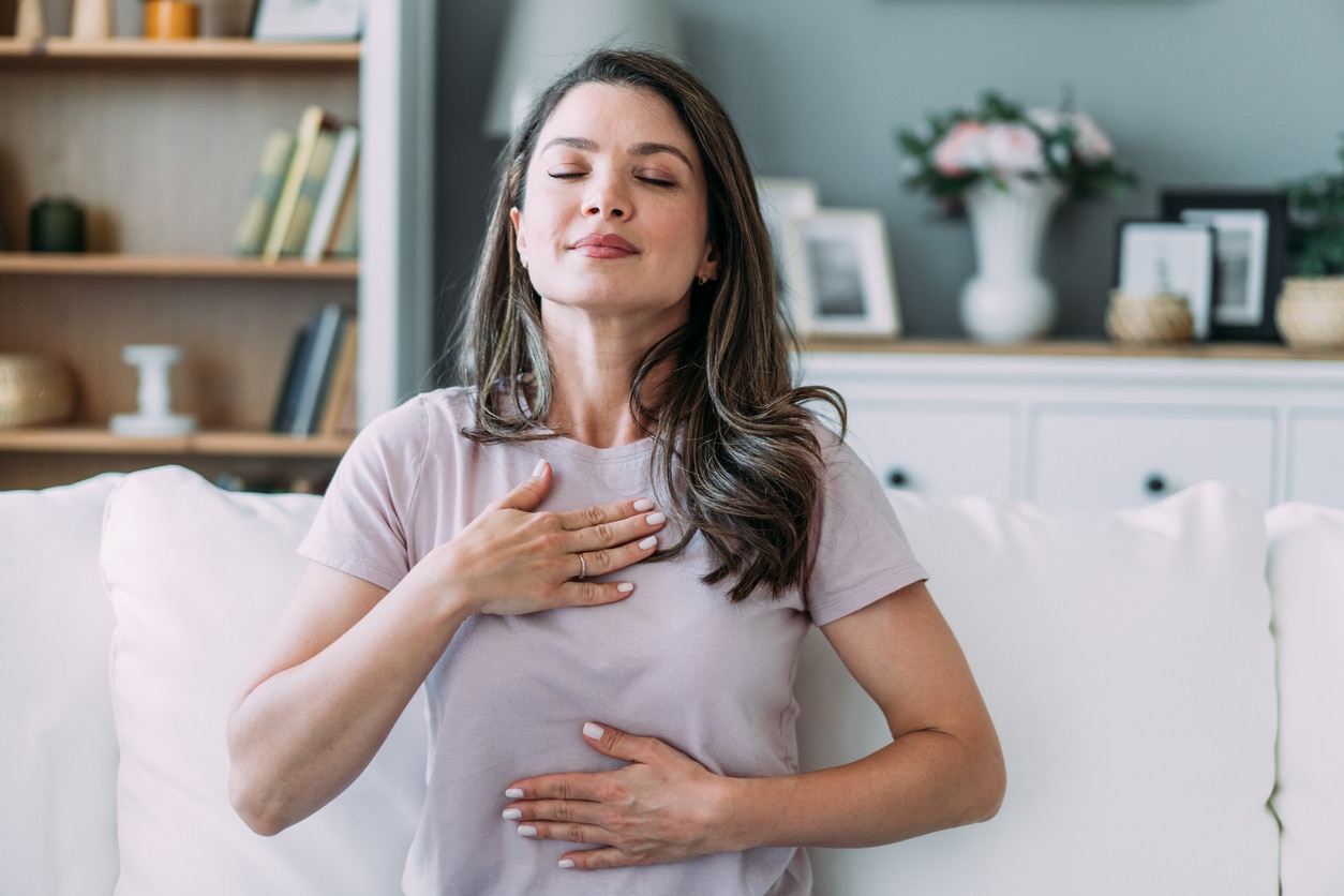 Woman doing breathing exercises in her home.